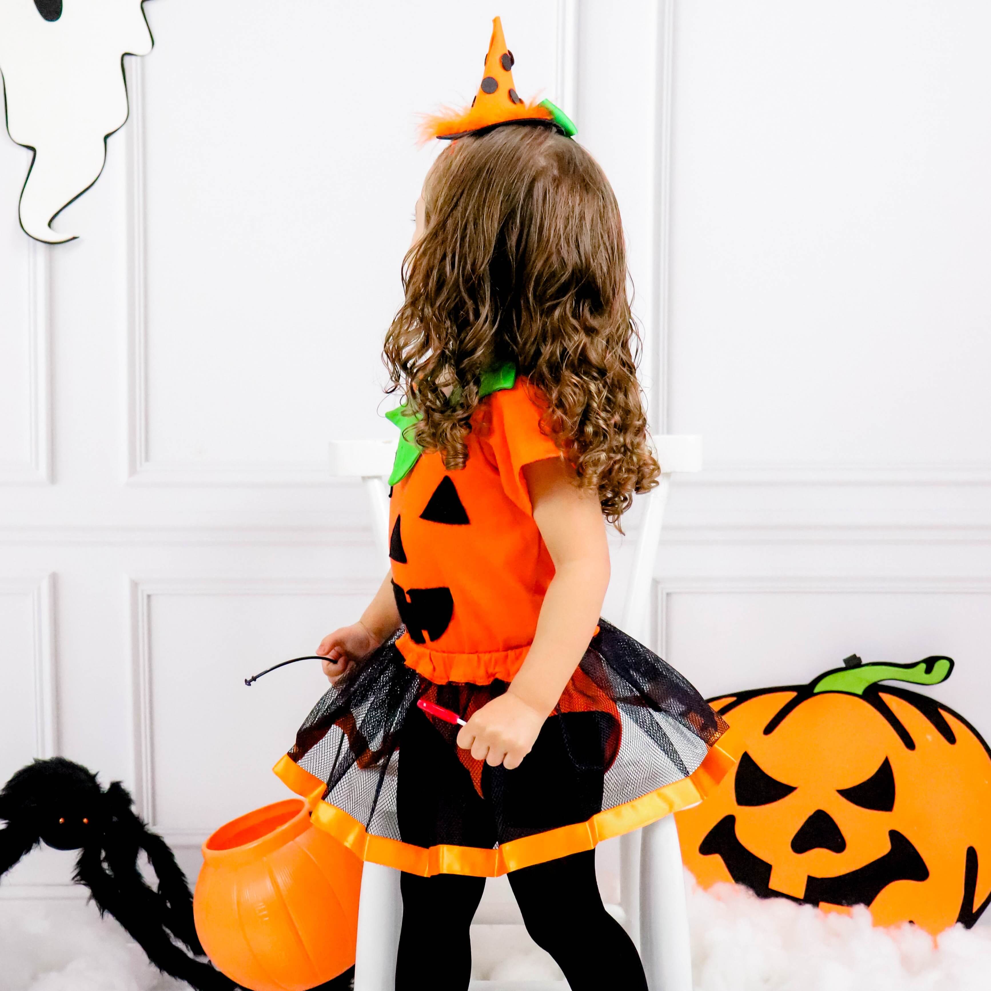 Um menino com uma fantasia de halloween fica em um campo.