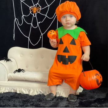 Um menino com uma fantasia de halloween fica em um campo.